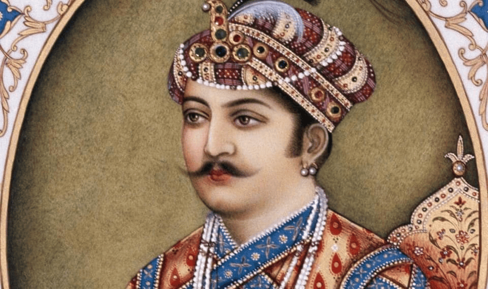 A detailed portrait of a man in traditional royal attire, wearing an ornate crown and decorated garments, with a subtle expression and well-groomed mustache.
