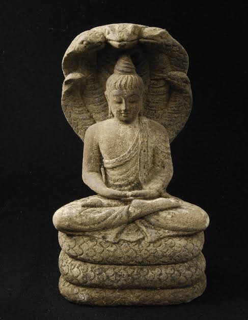 Stone statue of a seated Buddha with a serpent hood, symbolizing protection and wisdom.